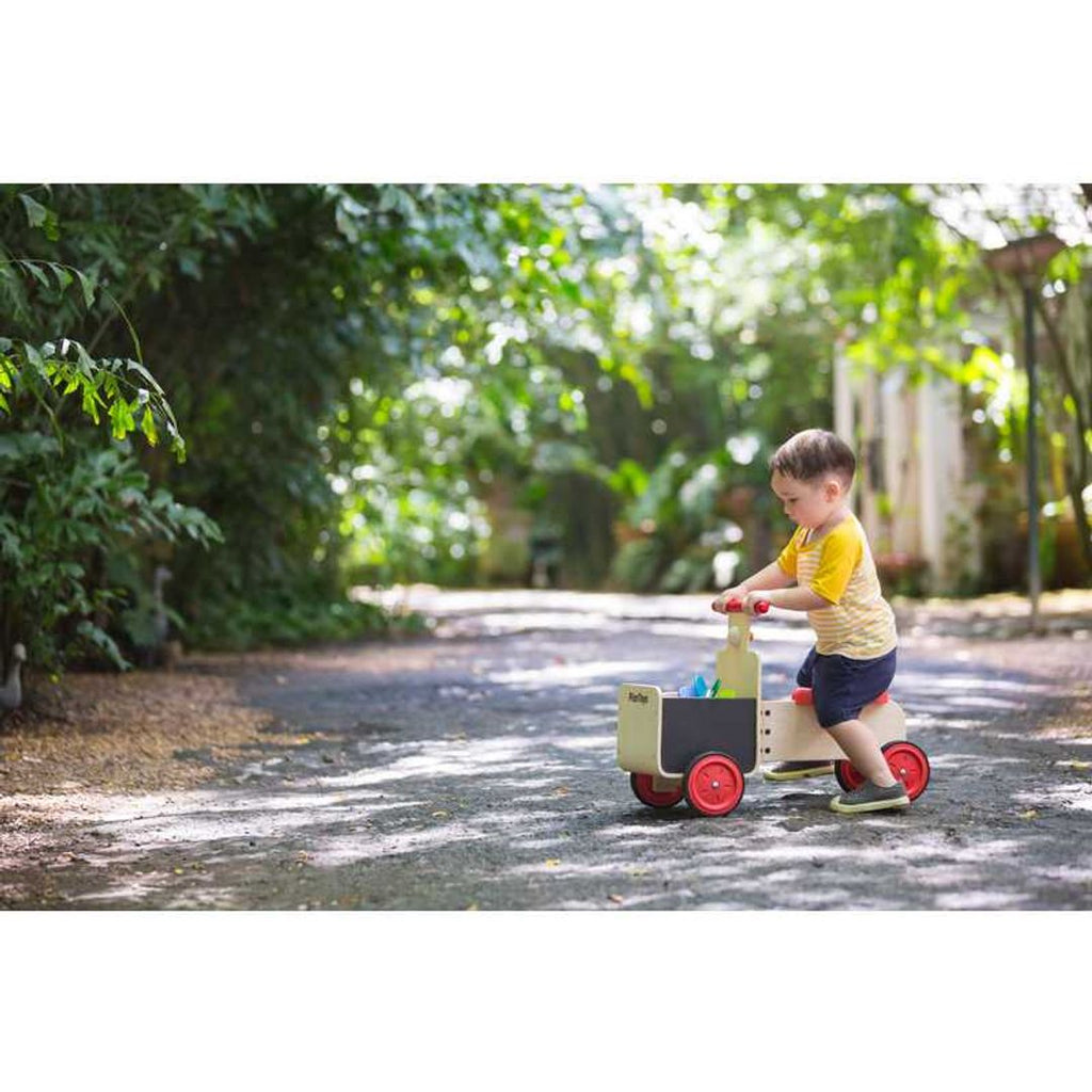 Kid playing PlanToys Delivery Bike