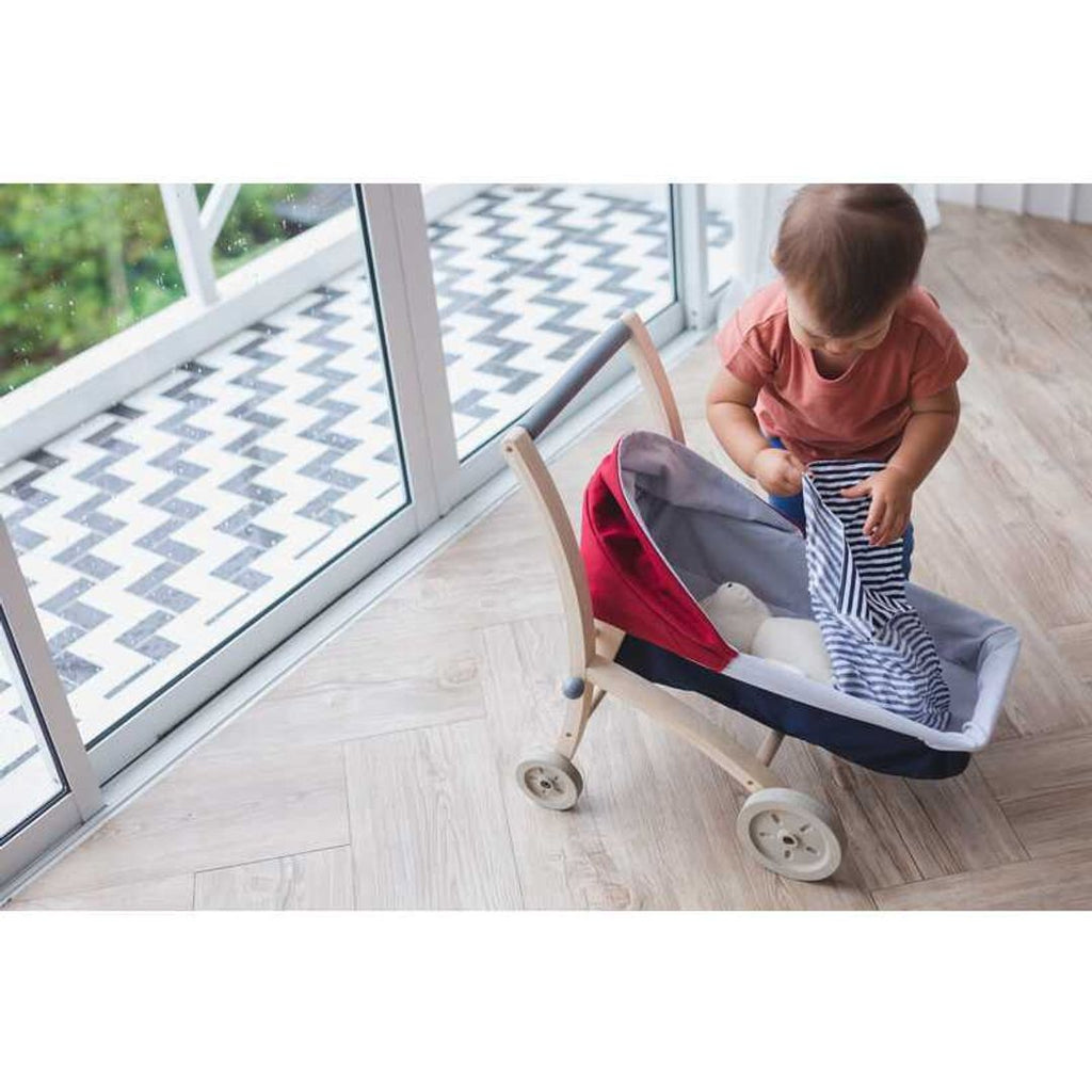 Kid playing PlanToys Doll Stroller