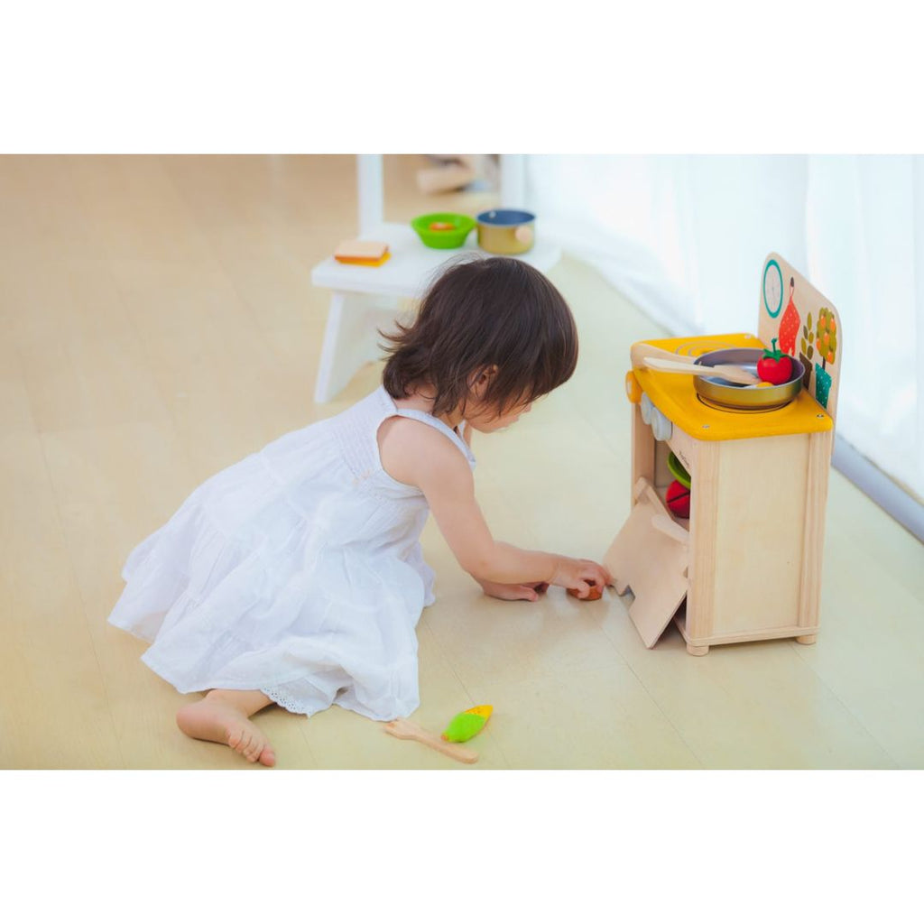 Kid playing PlanToys Kitchen Set