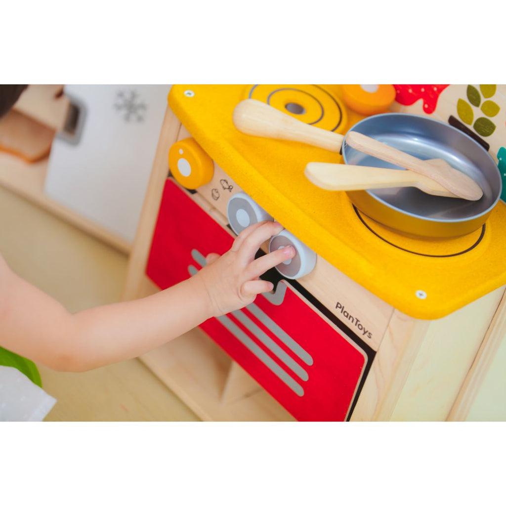 Kid playing PlanToys Kitchen Set