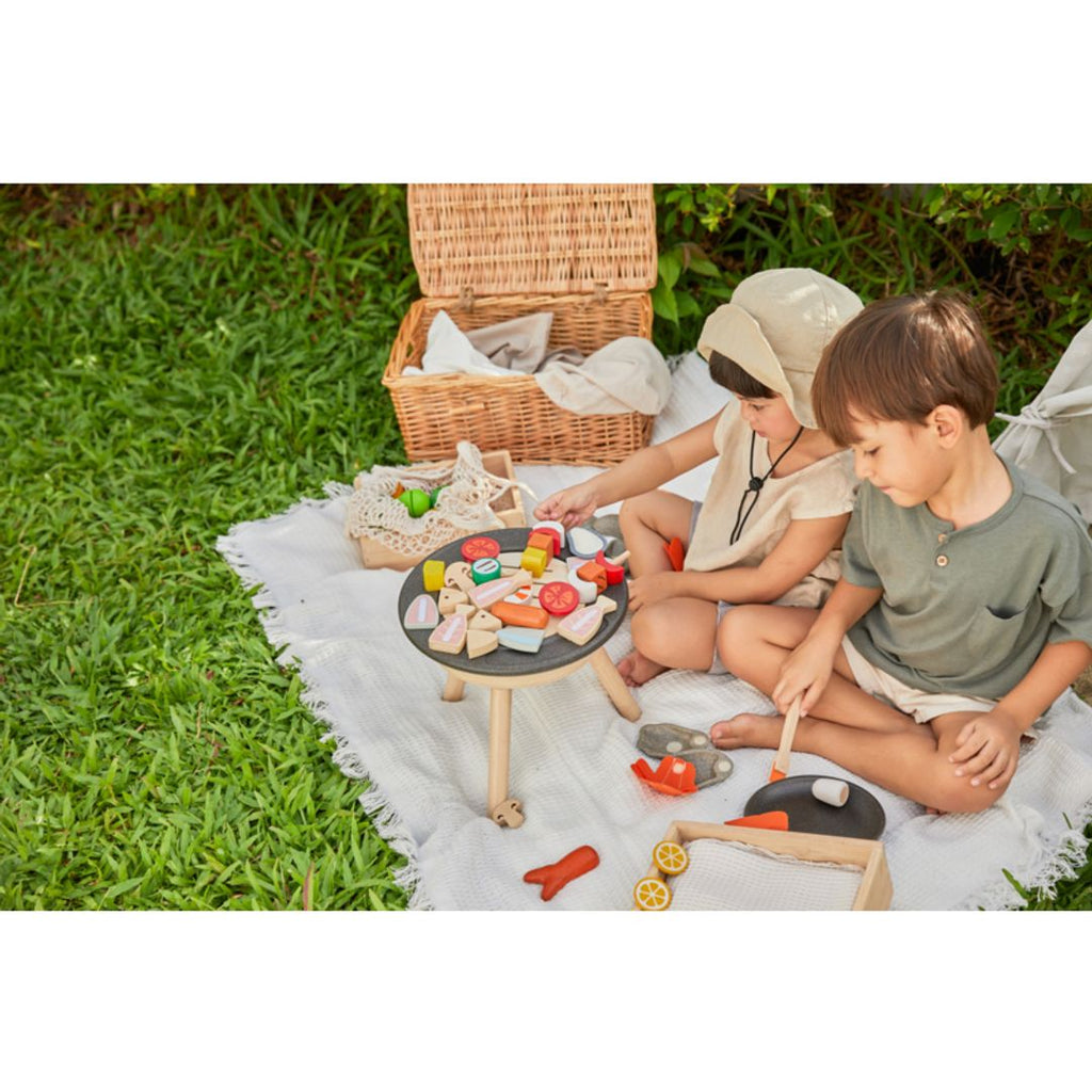 Kid playing PlanToys Bbq Playset