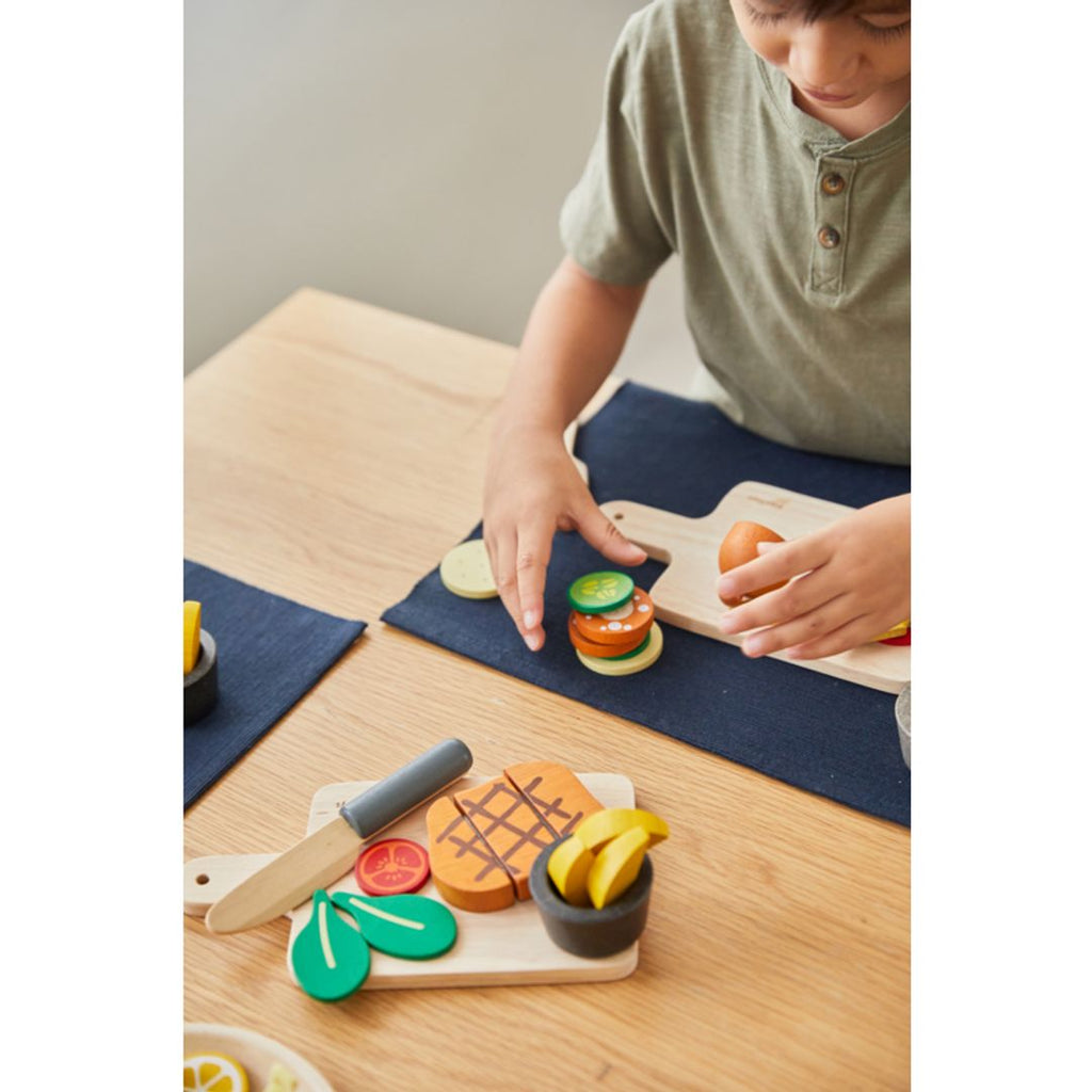 Kid playing PlanToys Steak Set