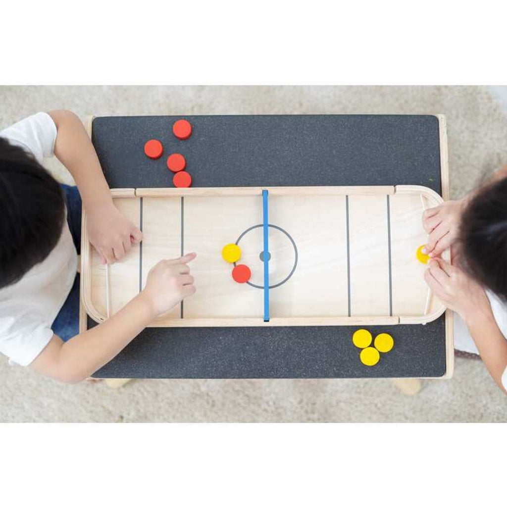 Kid playing PlanToys 2-In-1 Shuffleboard-Game