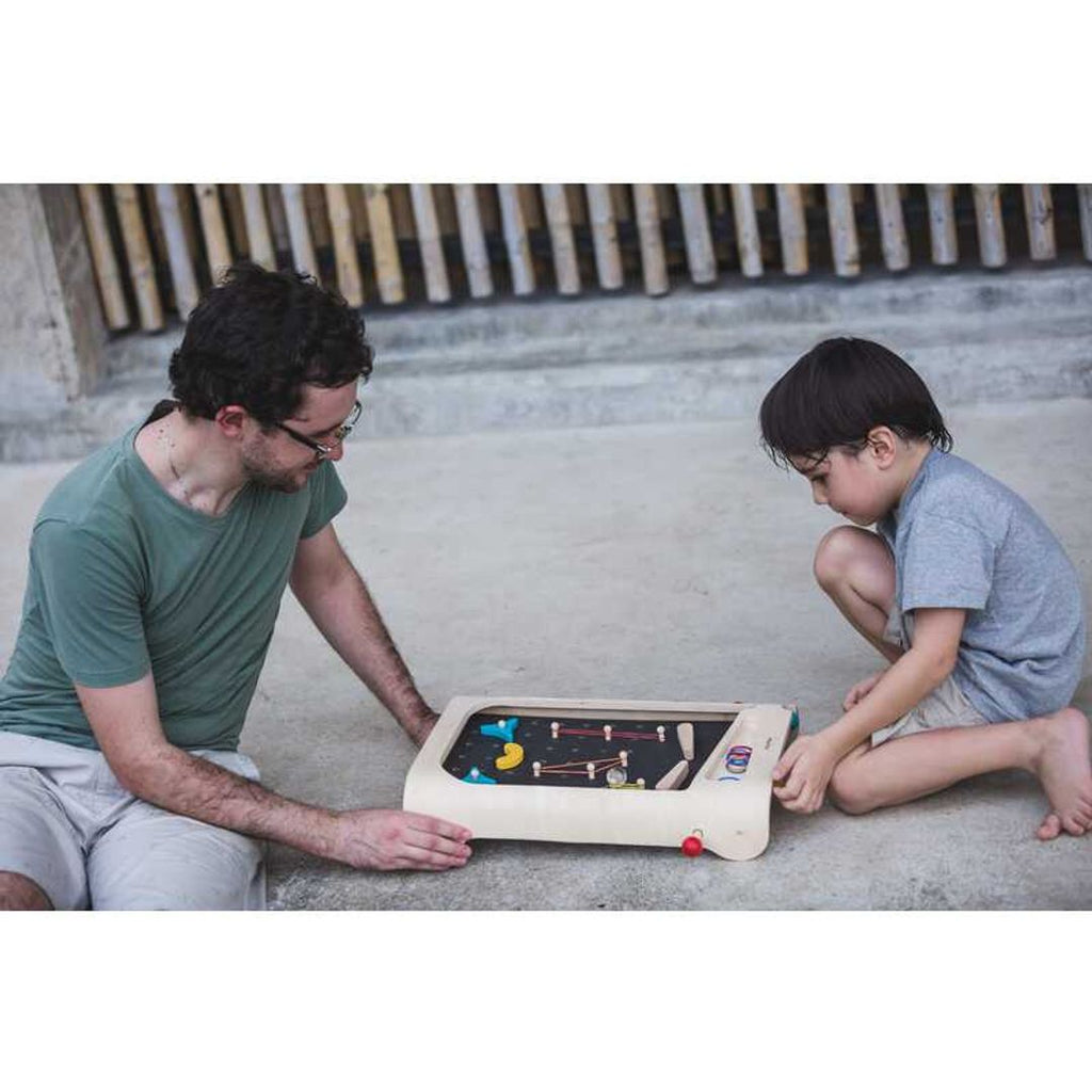 Kid playing PlanToys Pinball