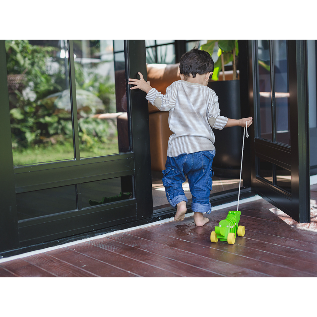 Kid playing PlanToys Dancing Alligator