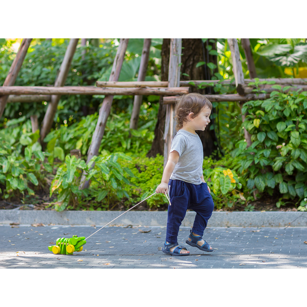 Kid playing PlanToys Dancing Alligator