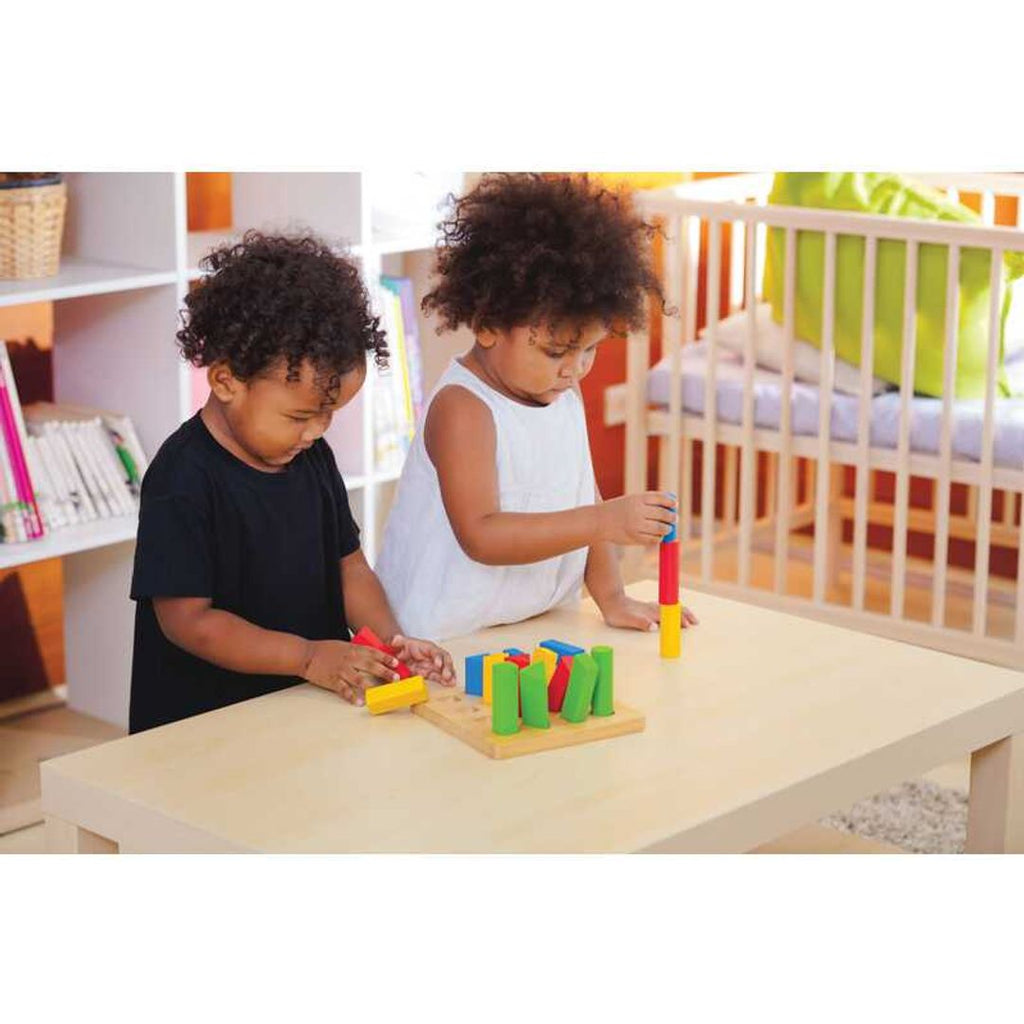 Kid playing PlanToys Geometric Peg Board