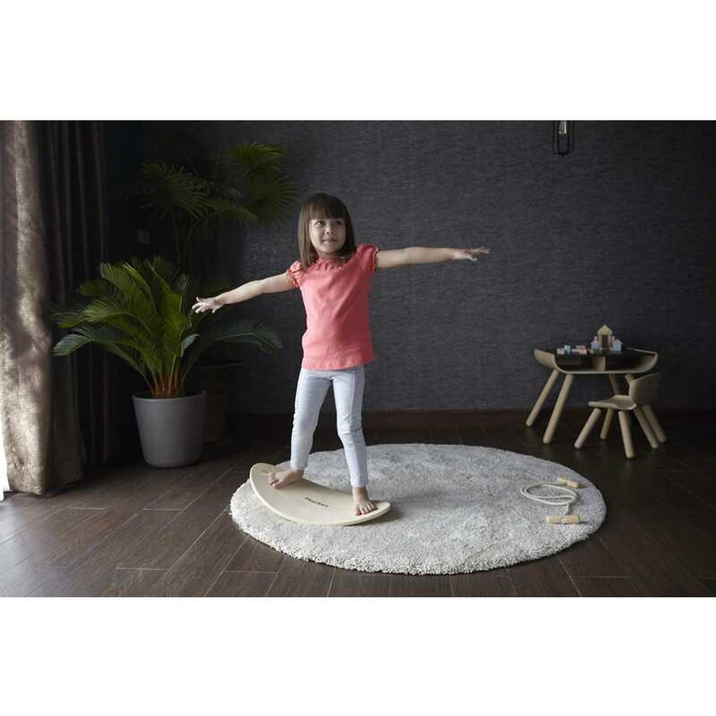 Kid playing PlanToys Balance Board