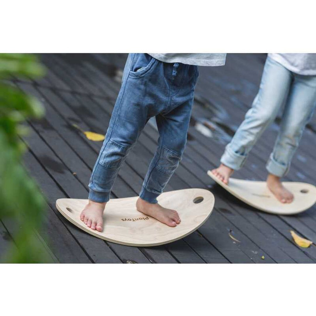 Kid playing PlanToys Balance Board