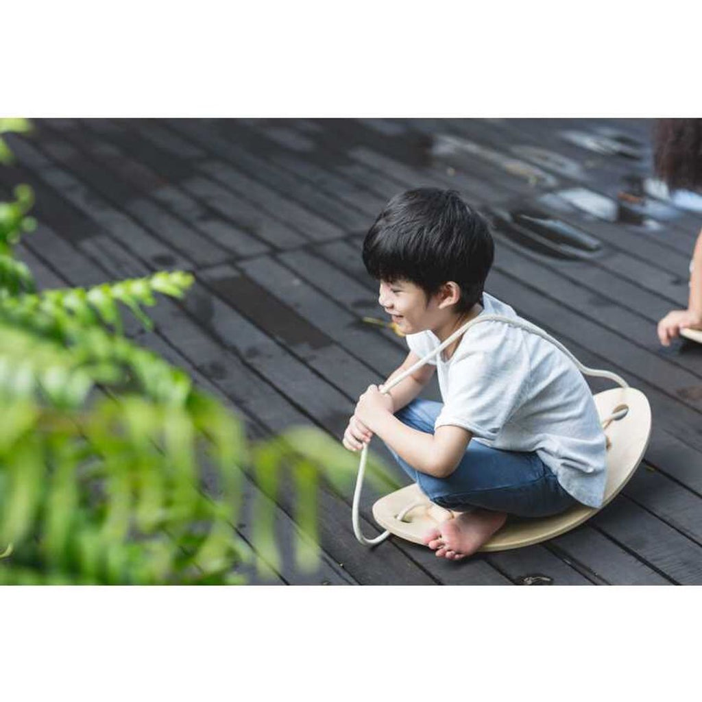 Kid playing PlanToys Balance Board