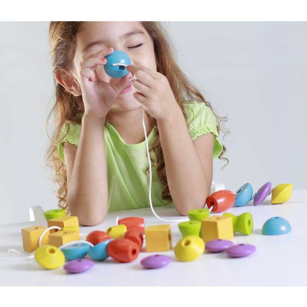 Kid playing PlanToys Lacing Beads