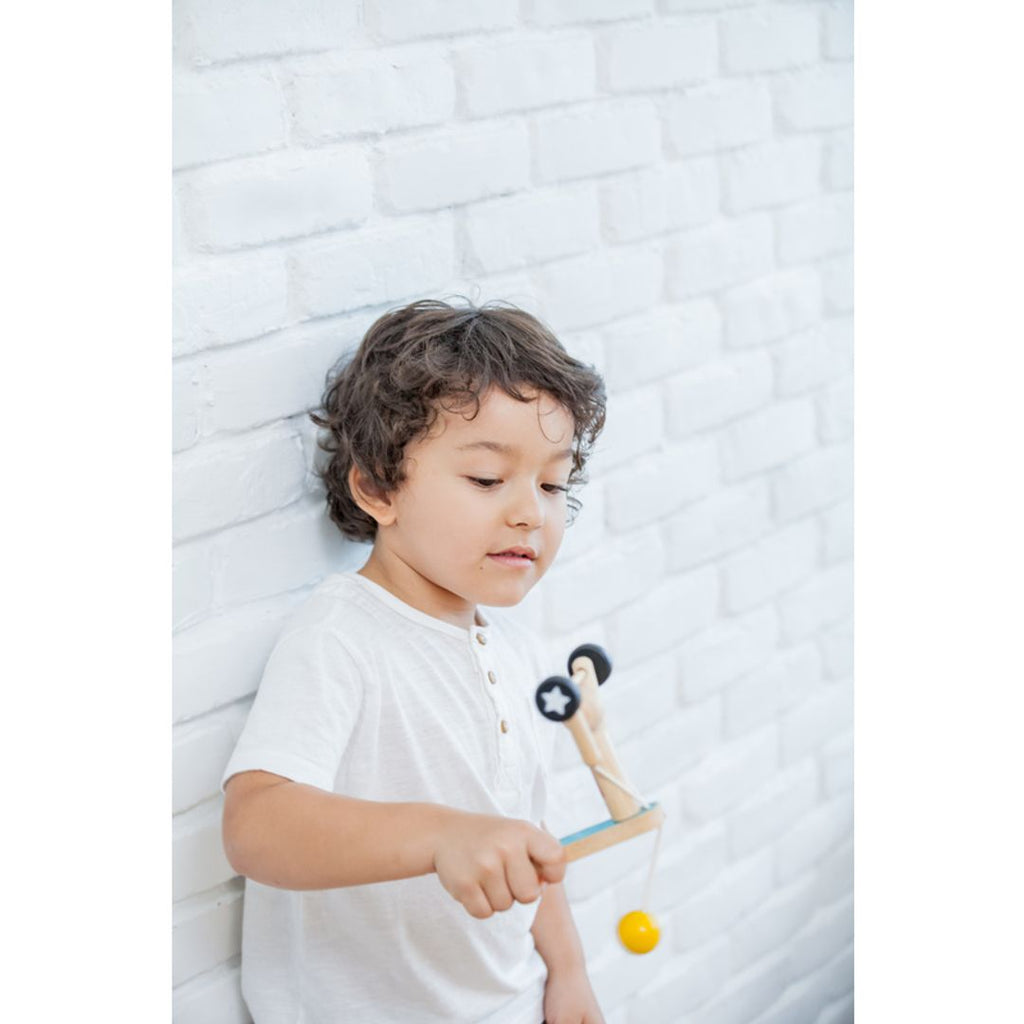 Kid playing PlanToys Weightlifting Acrobat