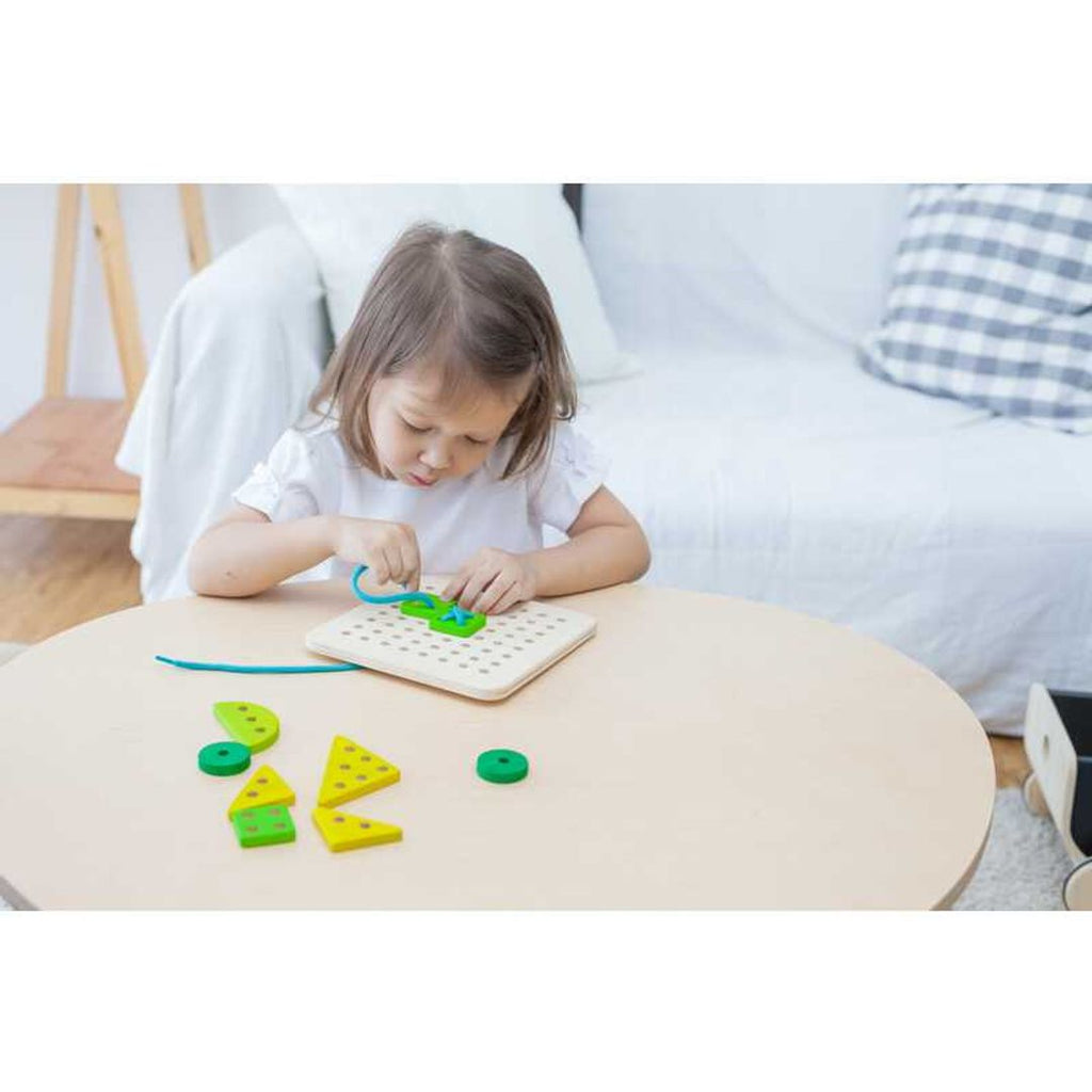 Kid playing PlanToys Lacing Board