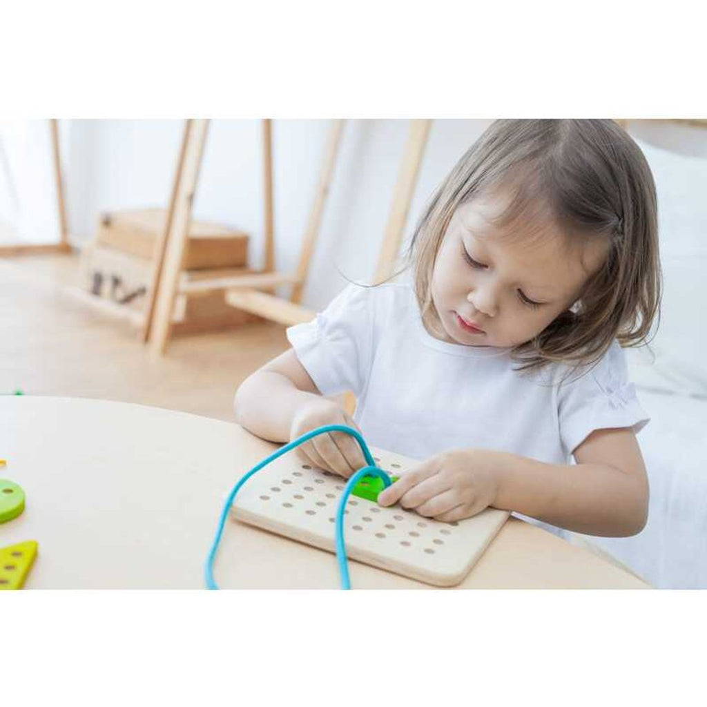 Kid playing PlanToys Lacing Board