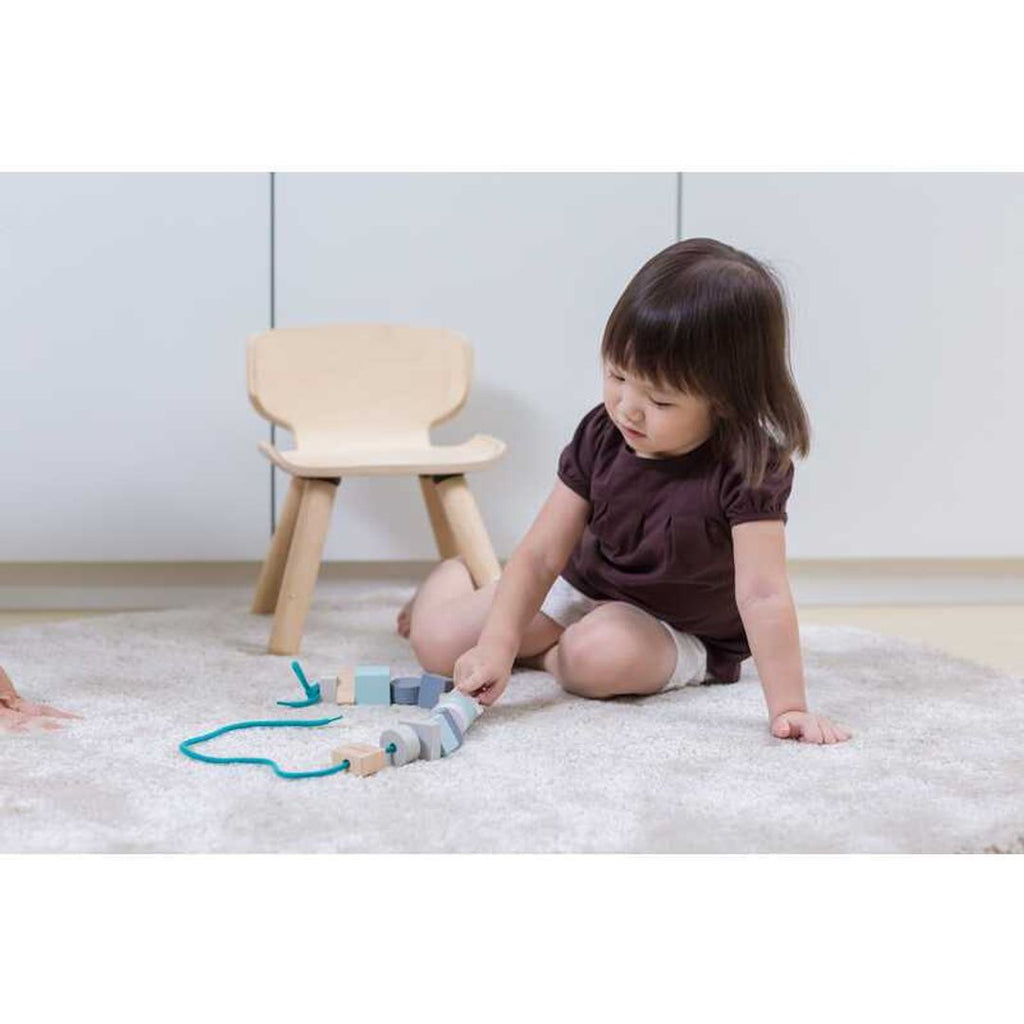 Kid playing PlanToys Geo Beads Lacing