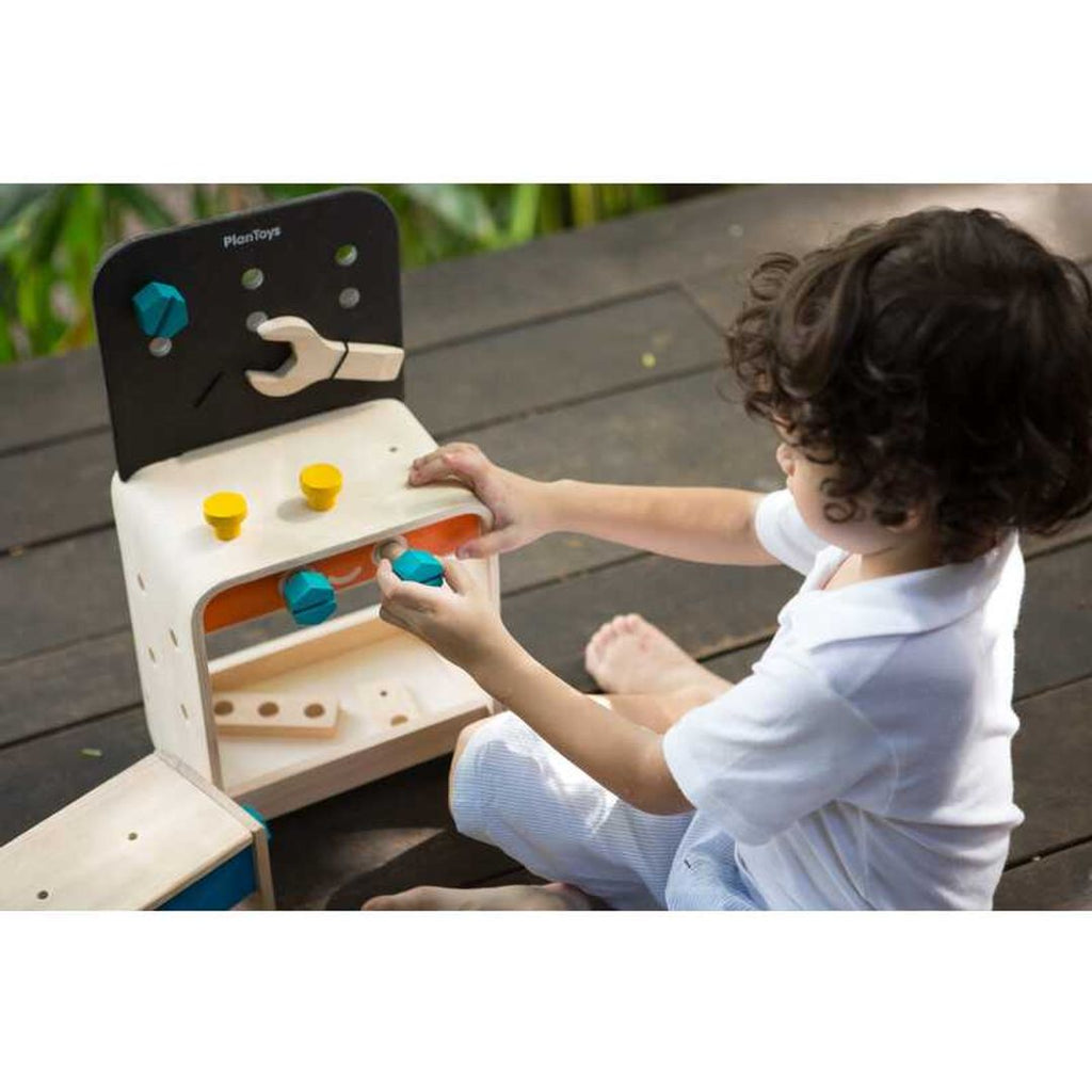 Kid playing PlanToys Workbench