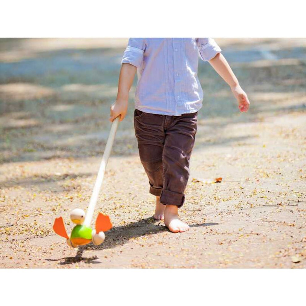 Kid playing PlanToys Push Along Duck