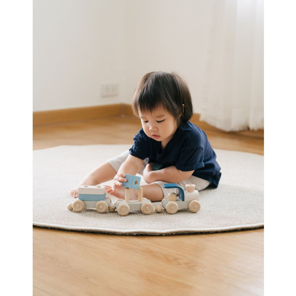 Kid playing PlanToys Stacking Train Trio - Orchard