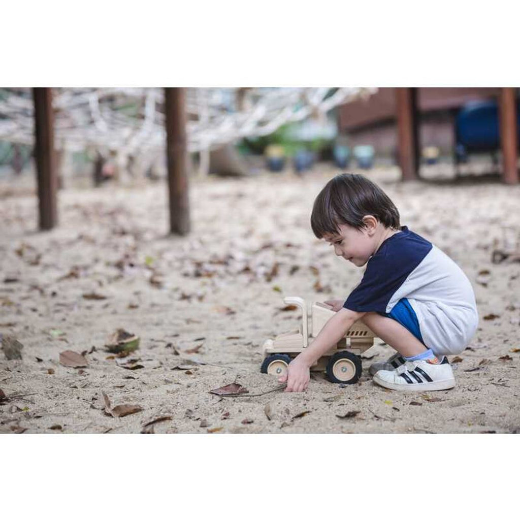 Kid playing PlanToys Dump Truck