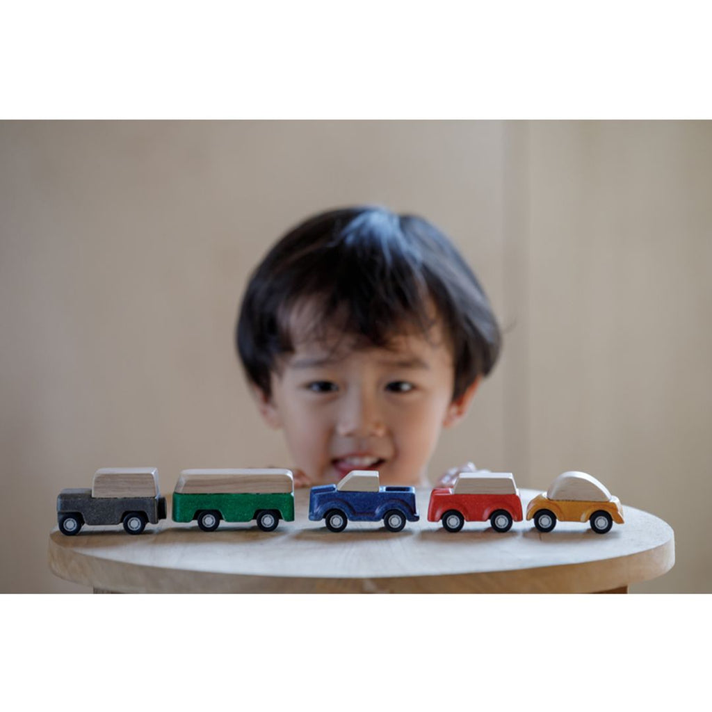 Kid playing PlanToys cars