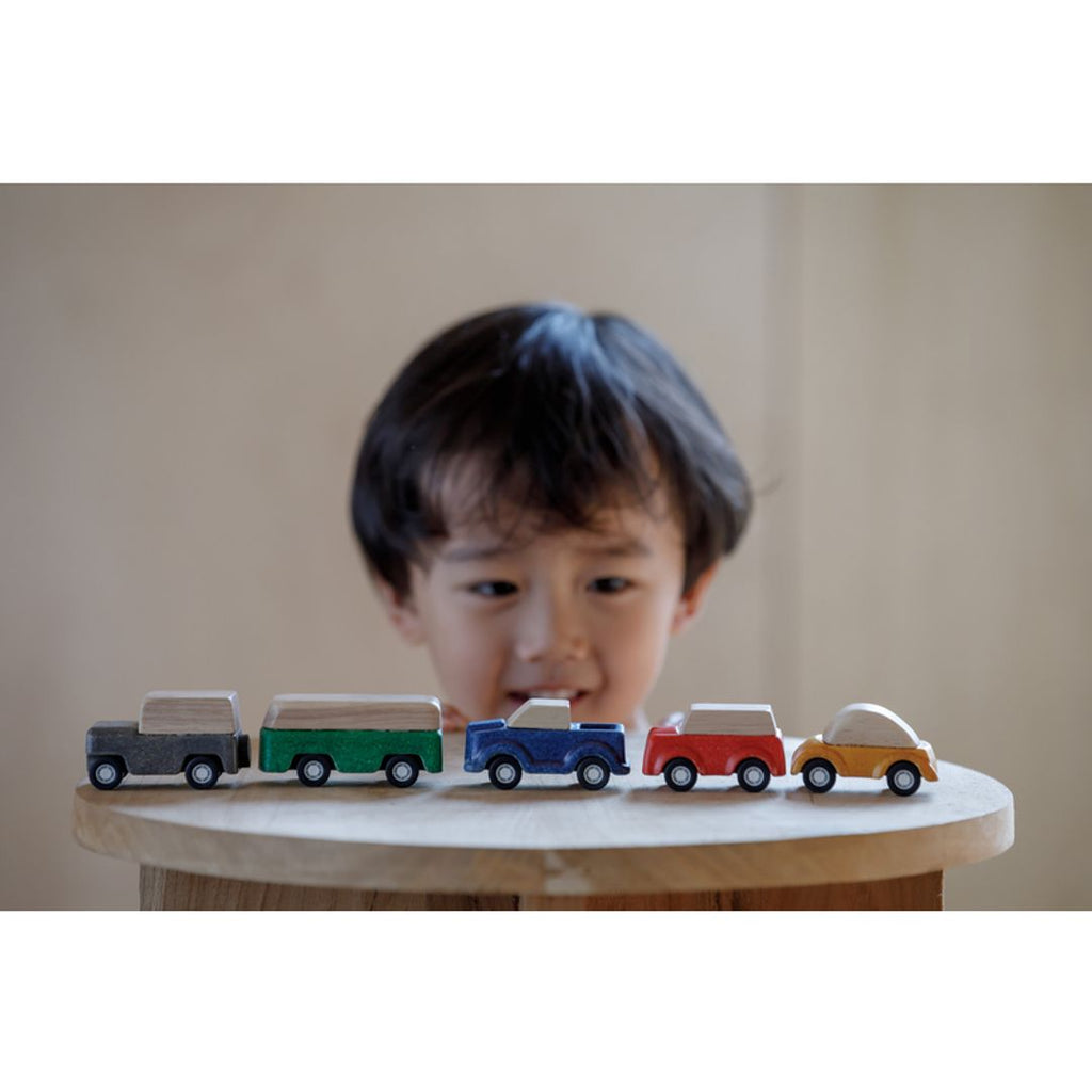 Kid playing PlanToys cars