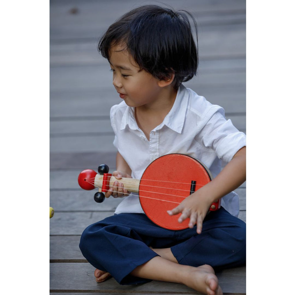 Kid playing PlanToys Banjo