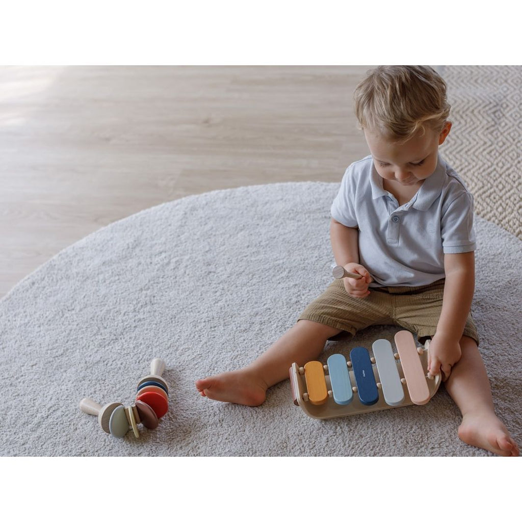 Kid playing PlanToys Oval Xylophone - Orchard Series