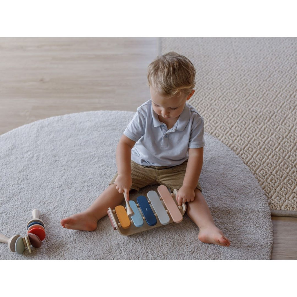 Kid playing PlanToys Oval Xylophone - Orchard Series