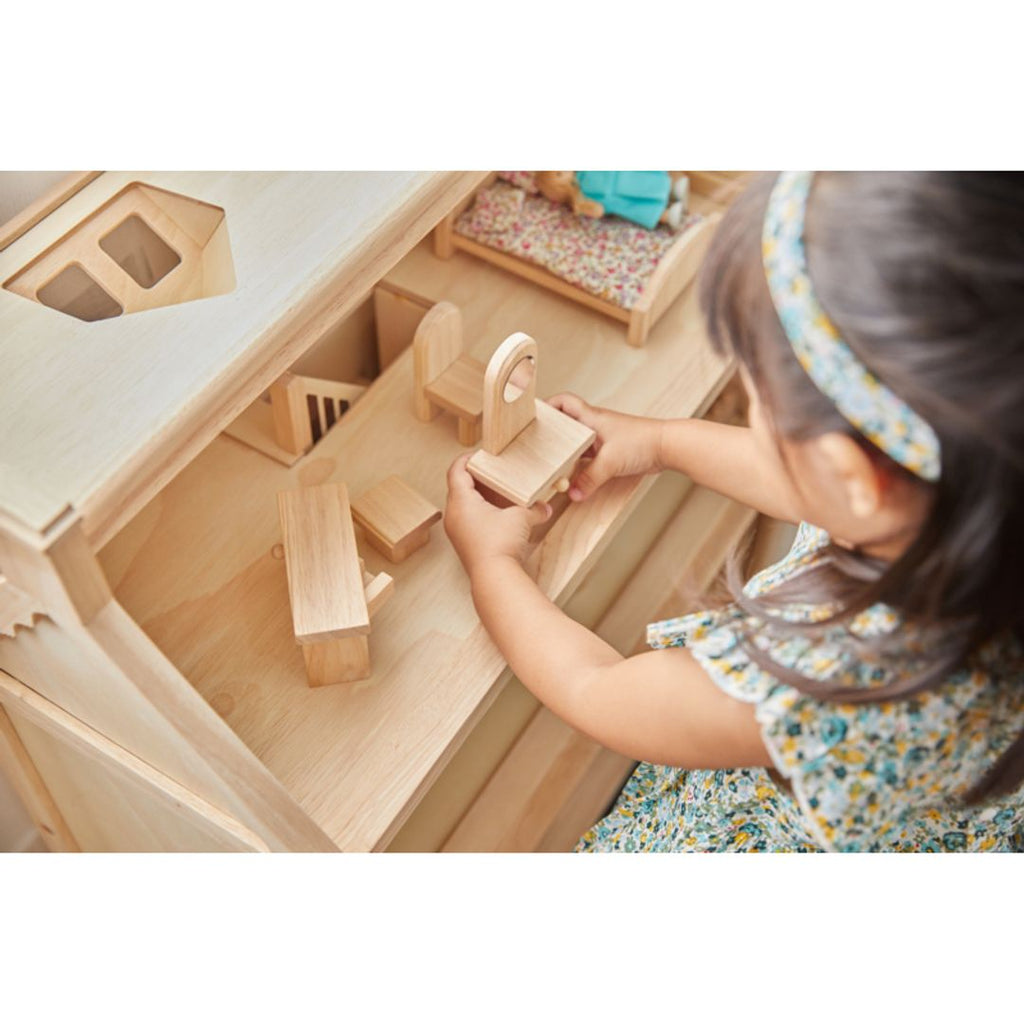 Kid playing PlanToys Victorian Dollhouse