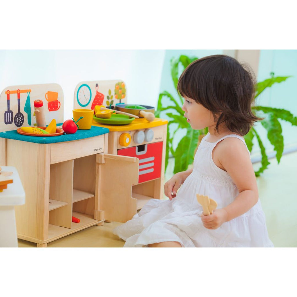 Kid playing PlanToys Kitchen Set