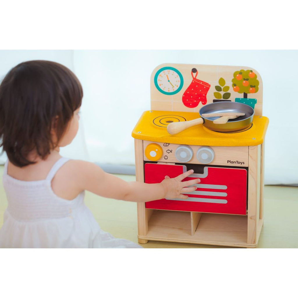 Kid playing PlanToys Kitchen Set