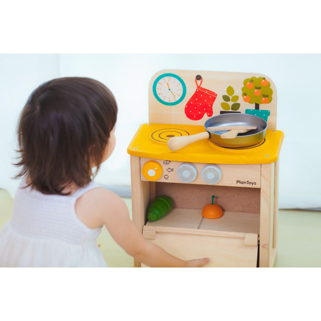 Kid playing PlanToys Kitchen Set