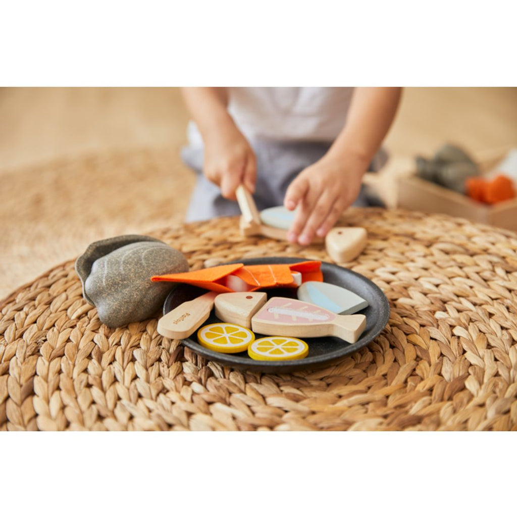 Kid playing PlanToys Seafood Platter