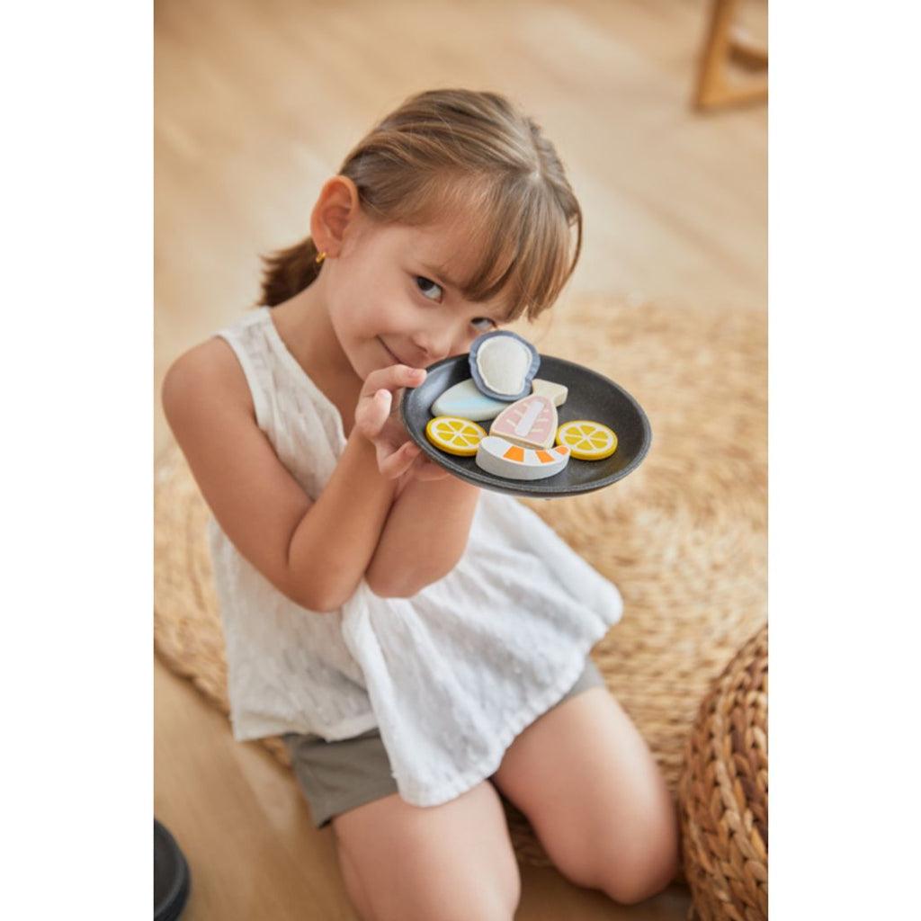 Kid playing PlanToys Seafood Platter