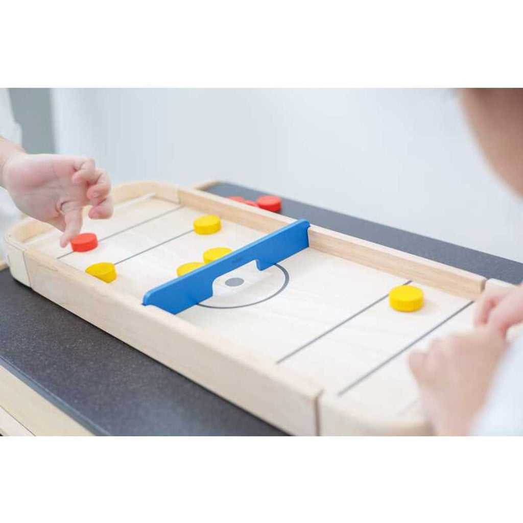 Kid playing PlanToys 2-In-1 Shuffleboard-Game