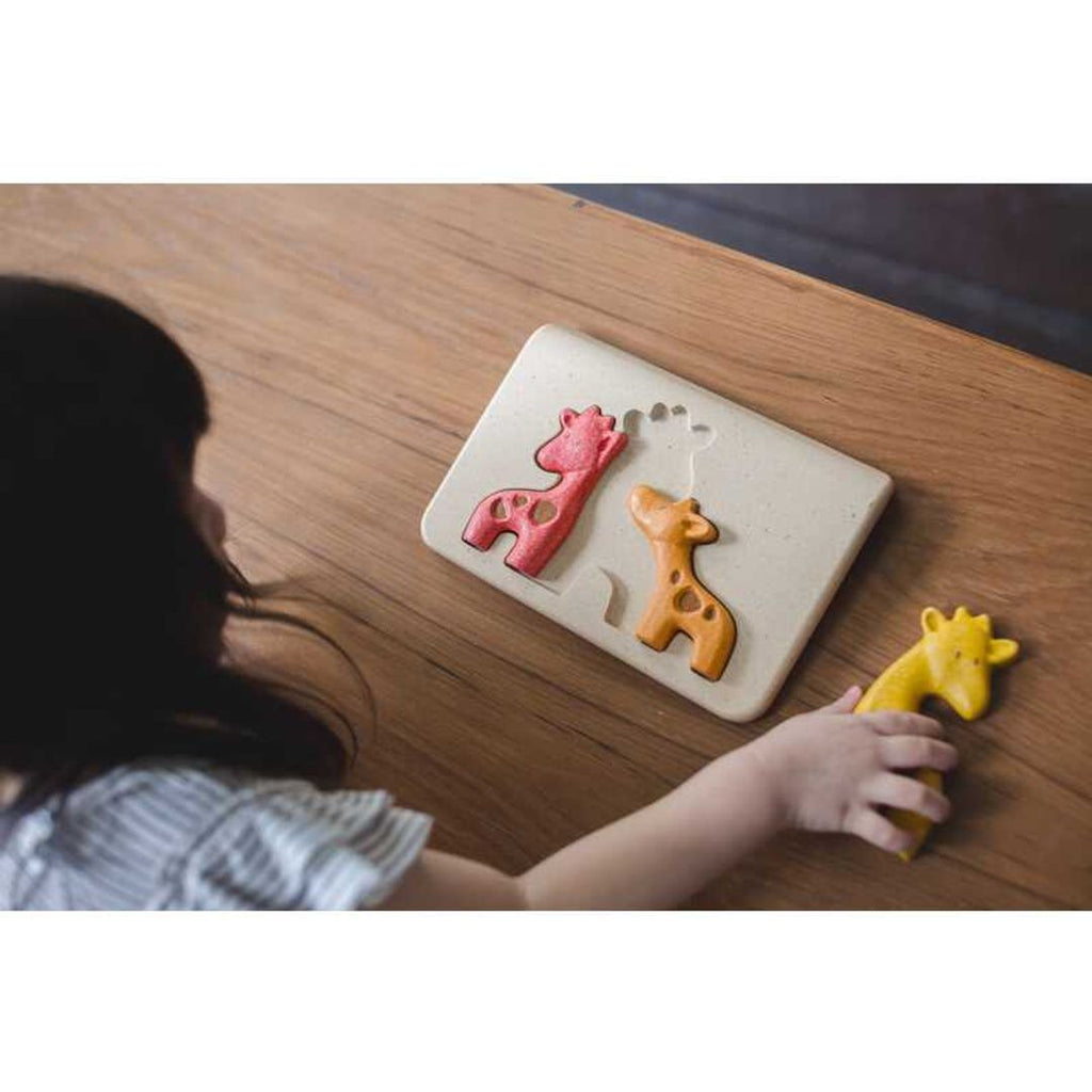 Kid playing PlanToys Giraffe Puzzle