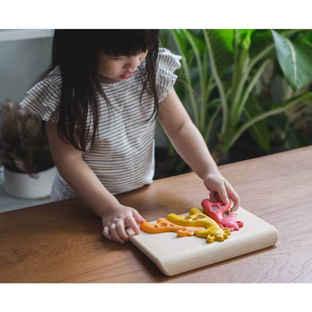 Kid playing PlanToys Giraffe Puzzle