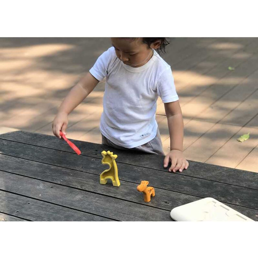 Kid playing PlanToys Giraffe Puzzle