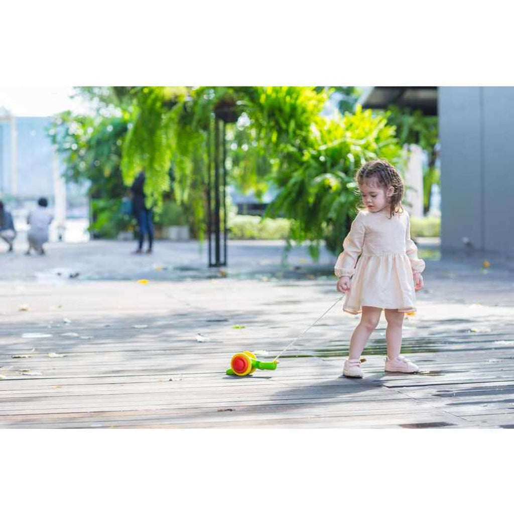 Kid playing PlanToys Pull Along Snail