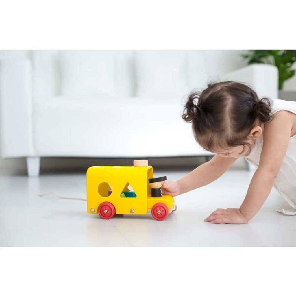 Kid playing PlanToys Sorting Bus