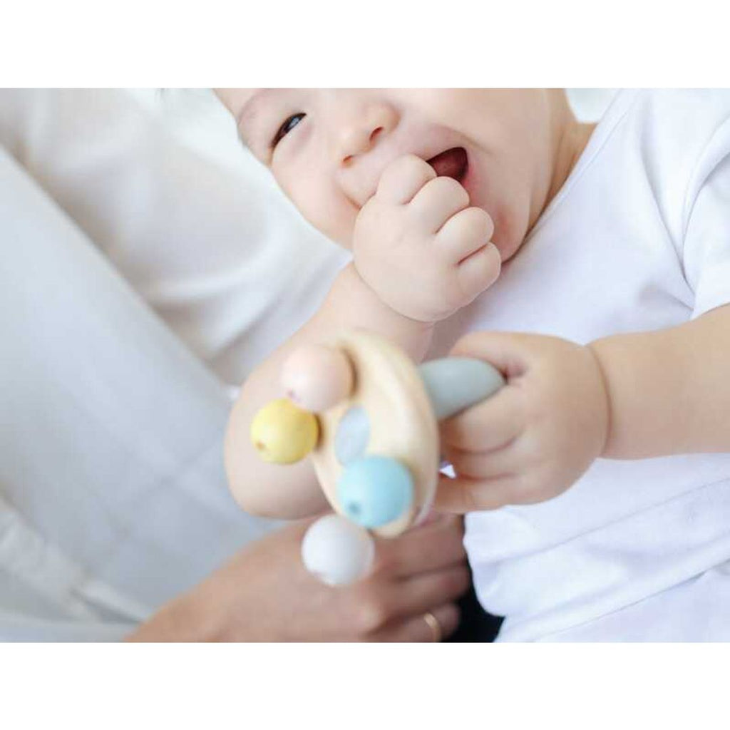 Kid playing PlanToys Bell Rattle - Pastel Series