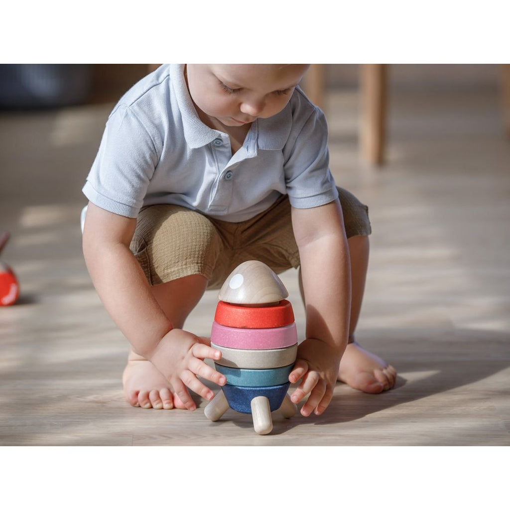 Kid playing PlanToys Stacking Rocket - Orchard Series