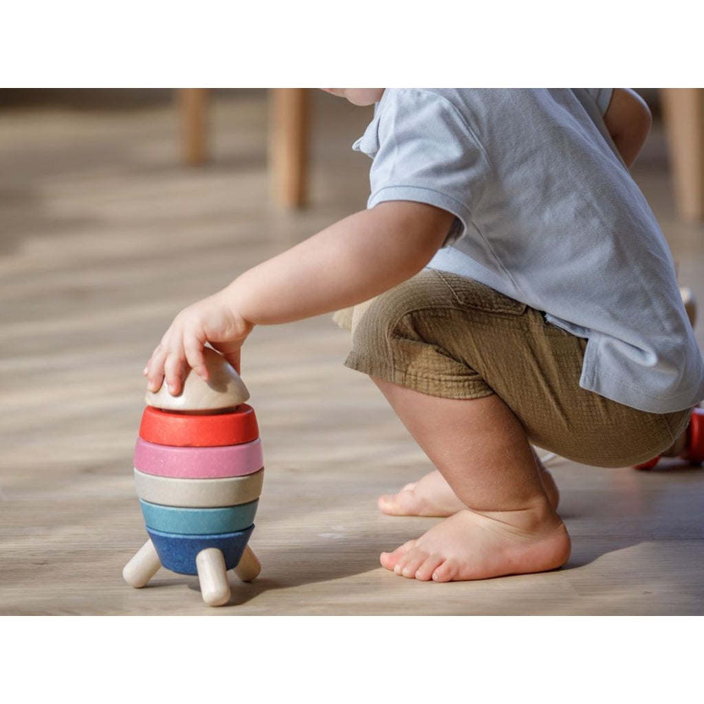 Kid playing PlanToys Stacking Rocket - Orchard Series