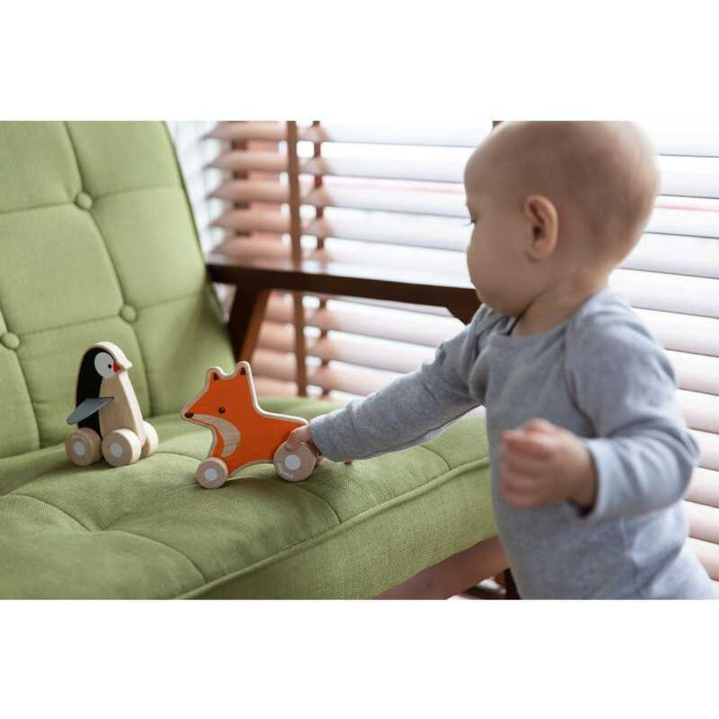 Kid playing PlanToys Fox Wheelie and Penguin Wheelie