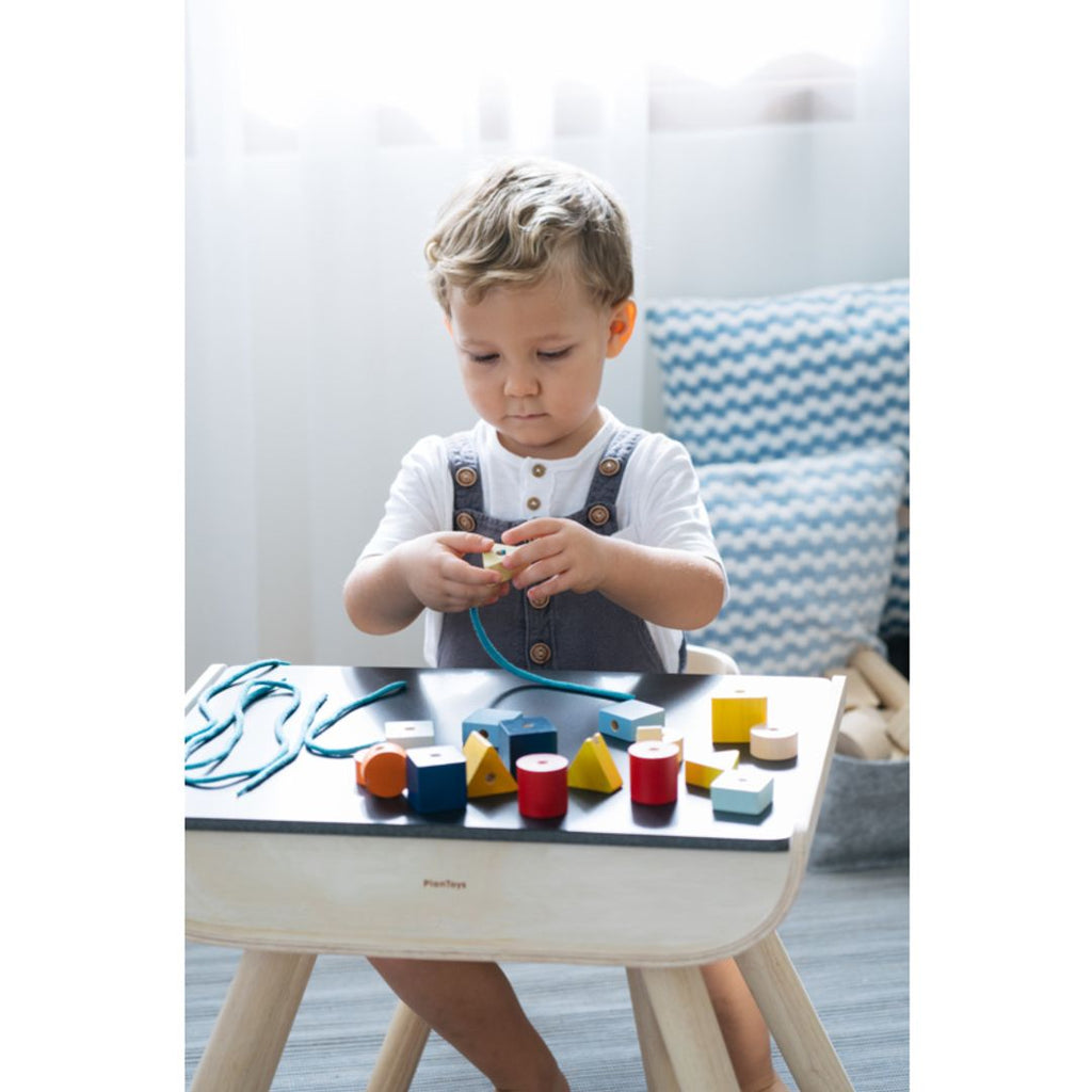 Kid playing PlanToys Geo Lacing Beads - Unit Plus 