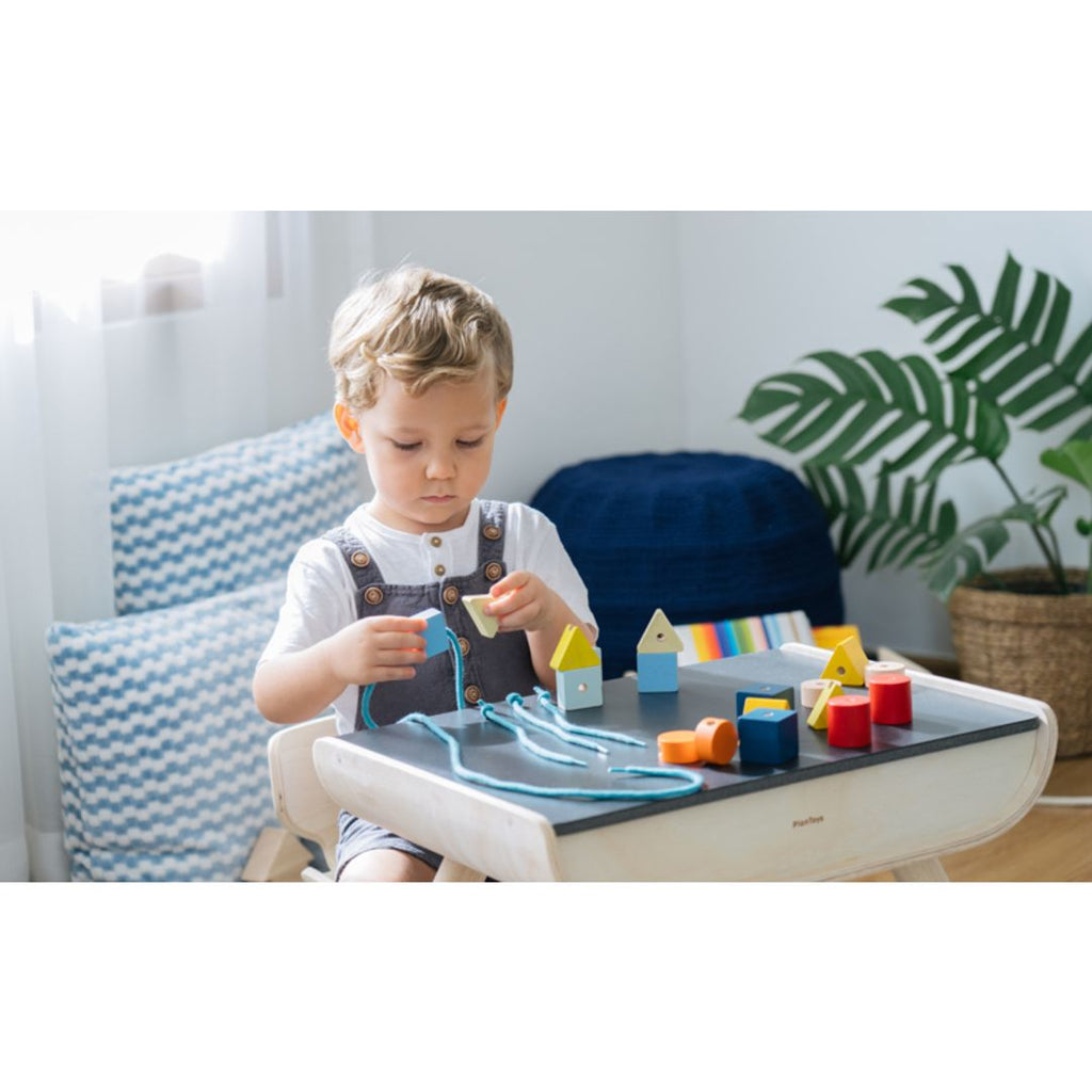 Kid playing PlanToys Geo Lacing Beads - Unit Plus 