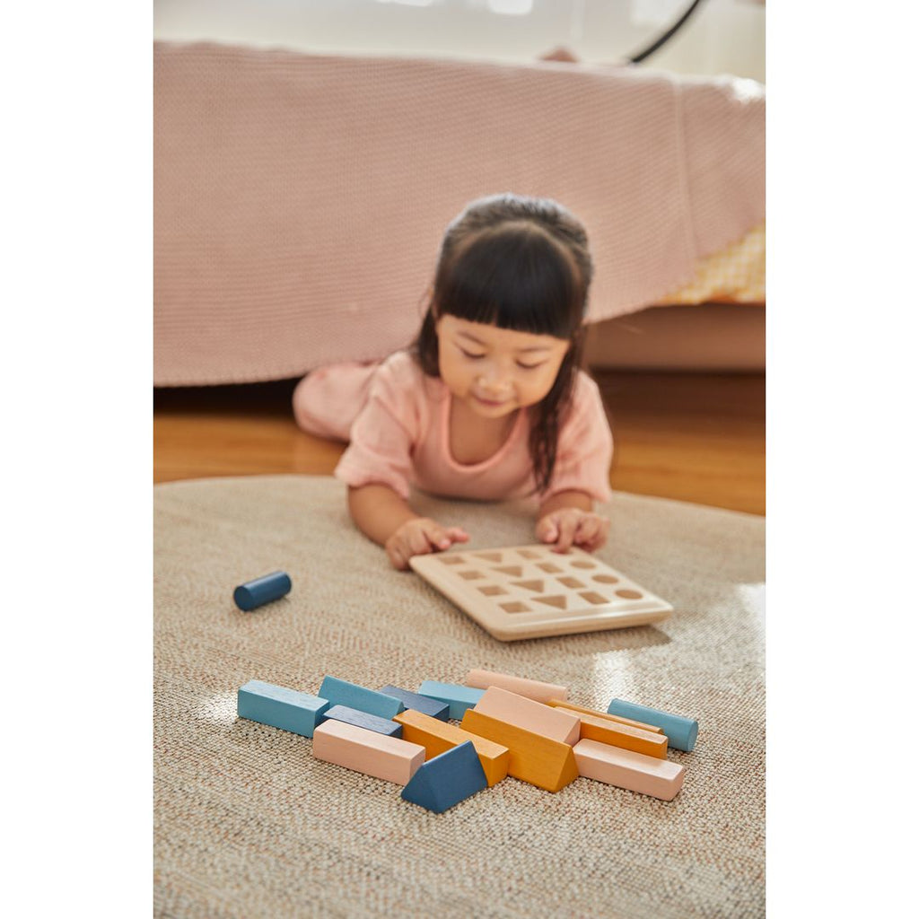 Kid playing PlanToys Geometric Peg Board - Orchard