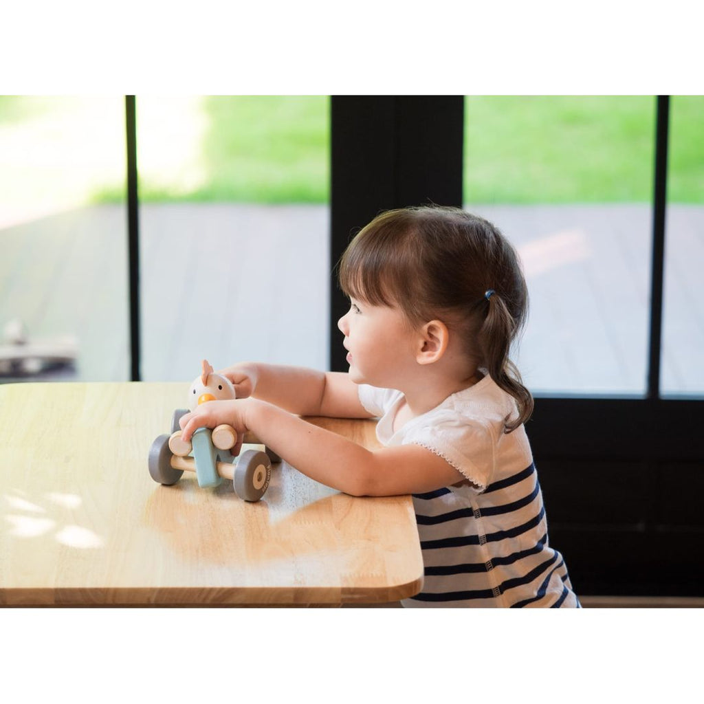 Kid playing PlanToys Chicken Racing Car