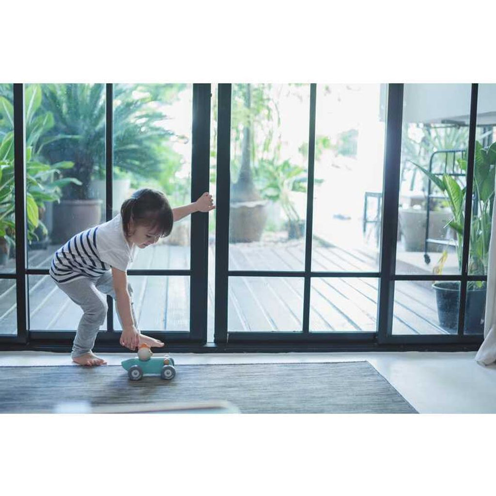 Kid playing PlanToys Chicken Racing Car