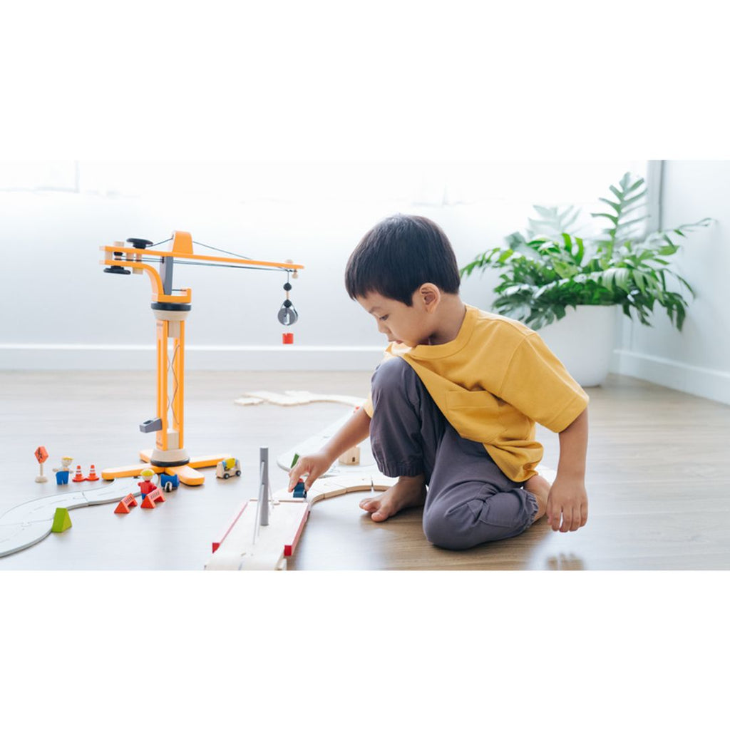 Kid playing PlanToys Crane Set